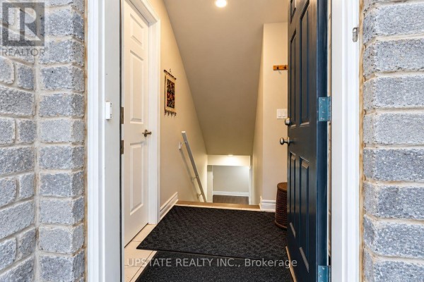 View looking into the home entrance with a staircase leading down to the basement. - (basement) - 8 Sage Meadow Crescent, Brampton