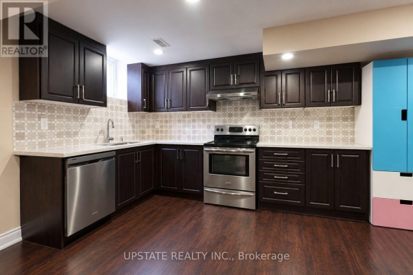 Basement kitchen with dark wood cabinets, stainless steel appliances, and light tiled backsplash. - (basement) - 8 Sage Meadow Crescent, Brampton