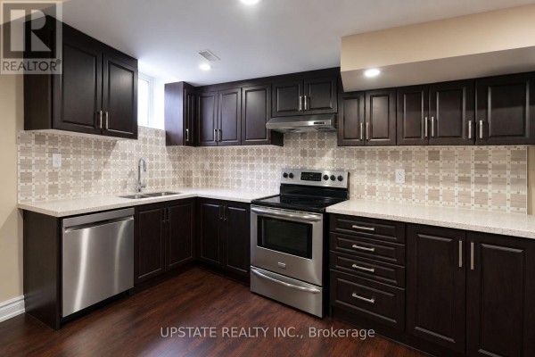 Basement kitchen with dark wood cabinets, stainless steel appliances, and light tiled backsplash. - (basement) - 8 Sage Meadow Crescent, Brampton