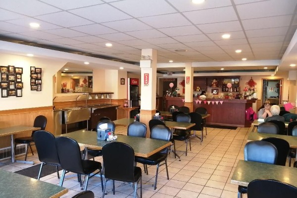 Dining area of Mr. Lin Family Restaurant with green tables, black chairs, and tiled floor. - , Provost