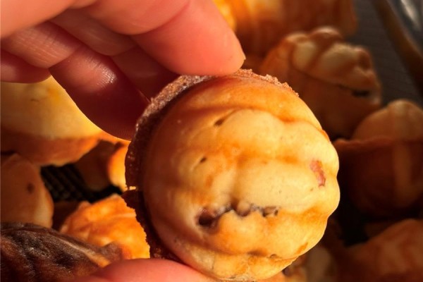 Hand holding a small pastry with a golden-brown exterior - . Cls Ave, Saanich
