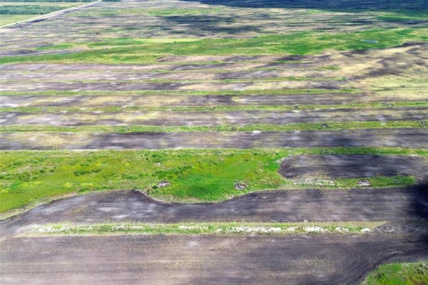 Aerial view of uneven terrain with patchy grass, small ponds, and dark soil patches. - 0 481 Road, Ste Rose Du Lac