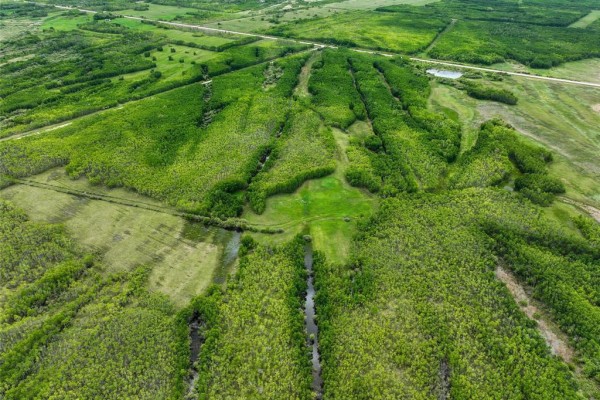 Expansive aerial view of green forested land with cleared paths and water features. - 0 68 Highway, Siglunes Rm
