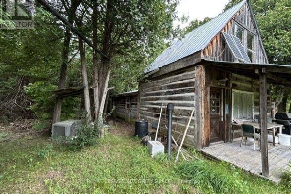 Interior view of cabin showing wood stove, propane stove, and table. - 0 Armstrong Road, Merrickville Wolford