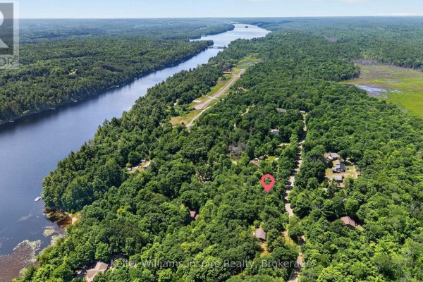 Aerial view showing waterfront property surrounded by mature trees and scattered houses. - 0 Baker Valley Road, Frontenac
