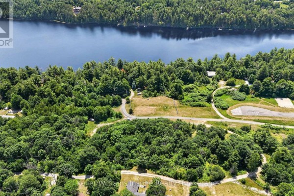 Overhead view of a winding road through a forested area with a large blue lake in the background. - 0 Baker Valley Road, Frontenac