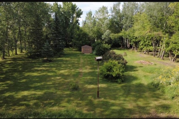 A 'Church Rd' sign and stop sign are visible at the corner of a tree-lined property. - 0 Church Road, East Selkirk