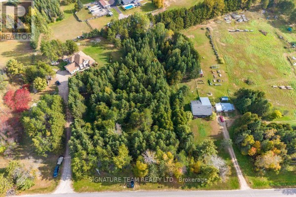 Overhead view of a property featuring a dense forest, a large house with a tan roof, and outbuildings. - 0 Dombroskie Road, Whitewater Region