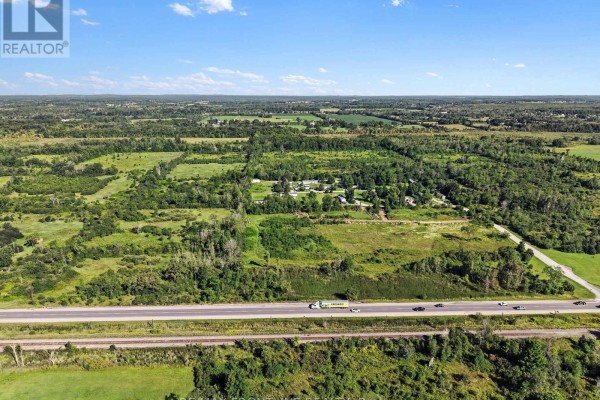 Aerial view of extensive land parcels with wooded areas and distant buildings next to a highway. - 0 Highway 7, Tay Valley