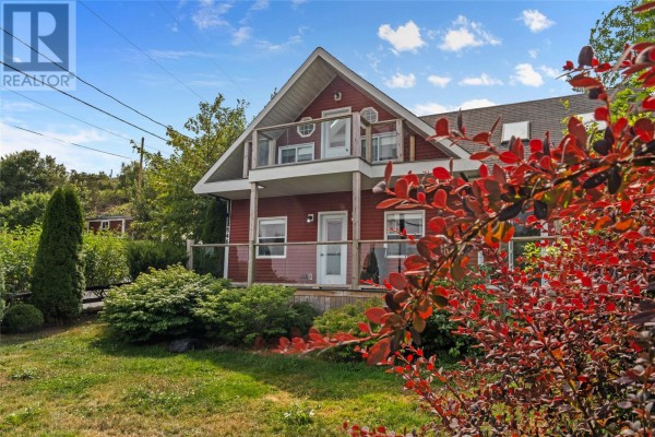 Red house with white trim and a covered porch, surrounded by green lawn. - 0 Main Road, Bauline East
