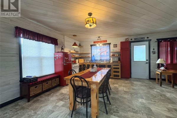 Kitchen with wooden cabinets, a dining table, and red appliances in an open-concept layout. - 0 Wilf Keats Road, Between Stanhope Brown S Arm