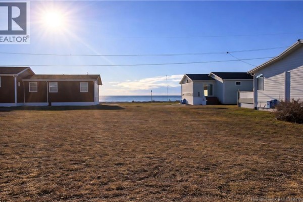 Several houses visible from a grassy field with the ocean in the background. - 0.2 Acres Rue Stella, Pointe Brulee