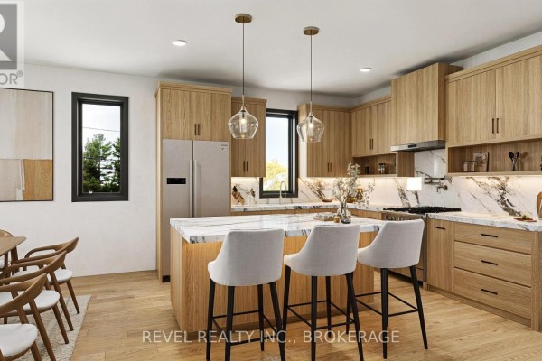 Kitchen with light wood cabinets, marble countertops, a large island with bar stools, and stainless steel appliances. - 00 Manitou Crescent, Loyalist