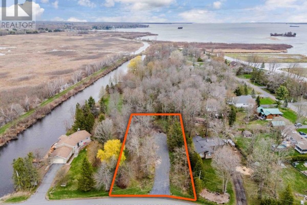Aerial view of a wooded parcel of land outlined in orange, situated between a canal and a larger body of water. - 0000 Tree Haven Road, South Glengarry
