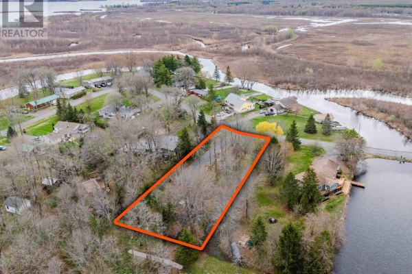 Aerial view of a rectangular, wooded lot outlined in orange, bordered by water on two sides and homes. - 0000 Tree Haven Road, South Glengarry