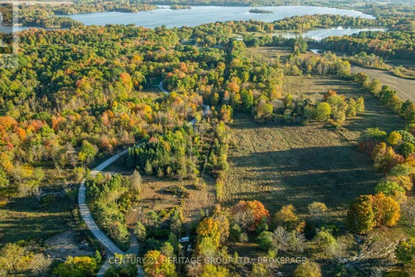 Panoramic aerial view of a large, treed property with roads, fields, and lakes. - 00000 Hideaway Lane, Frontenac