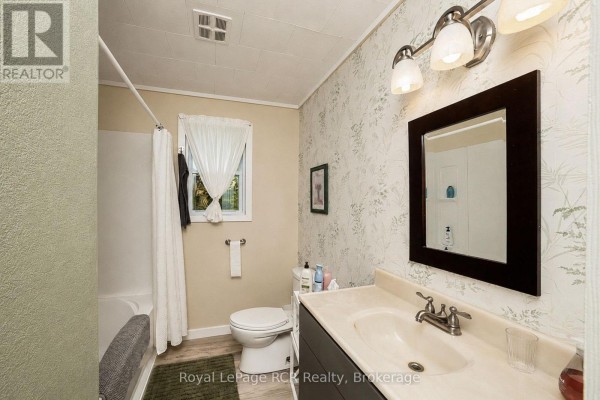 Bathroom with toilet, tub, vanity, mirror, and window - 046285 Old Mail Road Meaford
