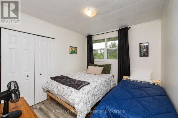 Bedroom with two beds, closet, window, and fan - 046285 Old Mail Road Meaford