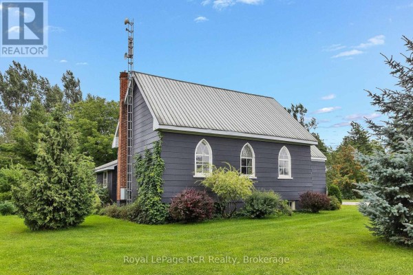 Dark gray building with gothic windows and antenna tower - 046285 Old Mail Road Meaford