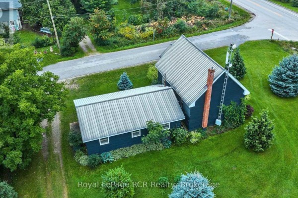 Dark blue house with metal roof and brick chimney - 046285 Old Mail Road Meaford