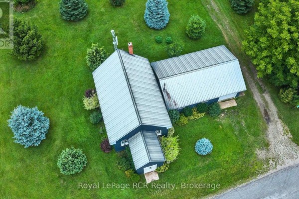 Aerial view of house with metal roof, chimney, and trees - 046285 Old Mail Road Meaford