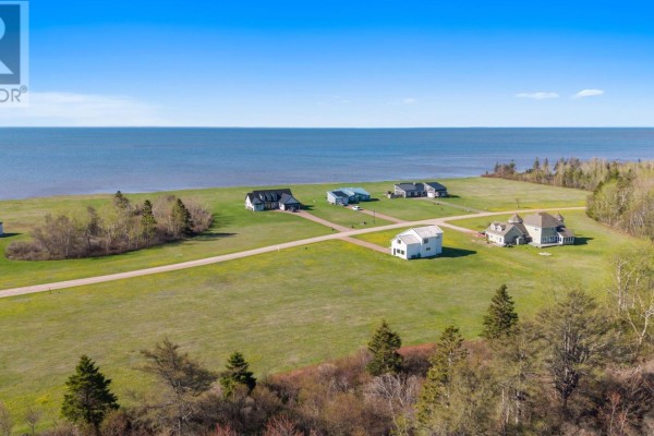Aerial view of houses situated on green lots with a large body of water in the distance. - 06-24 Stacy Lane, St  Nicholas
