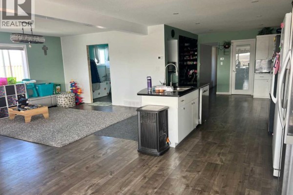 Wooden deck with two small trampolines and a railing, overlooking a hilly landscape. - 1, 11409 Black And White Trail, Rural Cypress County