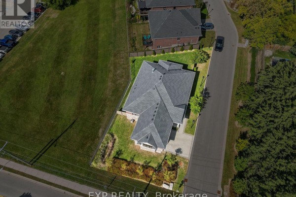 Aerial view of a suburban house with a grey shingle roof and green lawn. - 1 - 10038 Oxbow Drive, Middlesex Centre