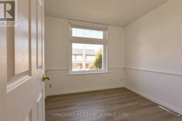 Bedroom with white walls, a large window, and laminate flooring. - 1 - 103 Mulcaster Street, Barrie