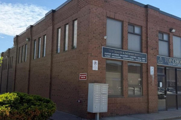 Side view of a brick commercial building with multiple windows and landscaping on the left. - 1 - 11 Goodmark Place, Toronto