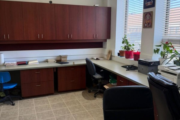 Office interior with long desks, dark wood cabinets, office chairs, plants, and window blinds. - 1 - 11 Goodmark Place, Toronto