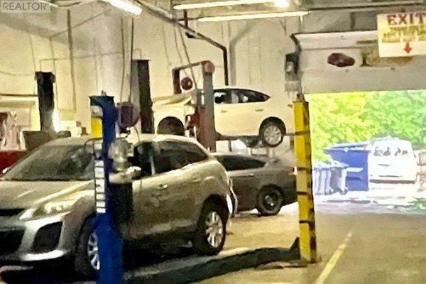Mechanics working on vehicles lifted by hydraulic car lifts in a garage. - 1 - 1287 Kennedy Road, Toronto