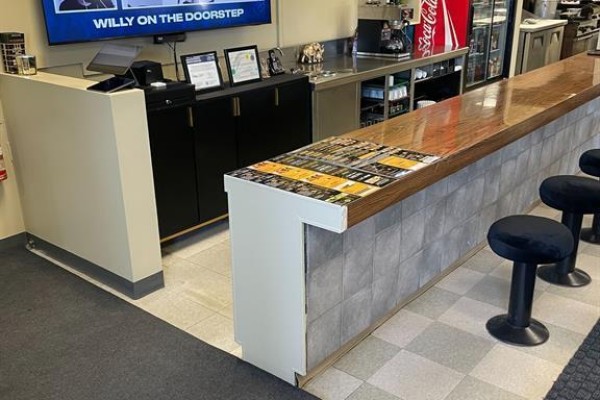 Interior diner counter with wood top, tiled base, and black stools. - 1 - 1335 Humber Place, Ottawa