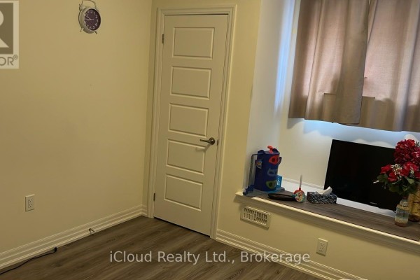 Corner of a room with a window, television, and a white paneled door. - 1 - 141 Marvin Avenue, Oakville