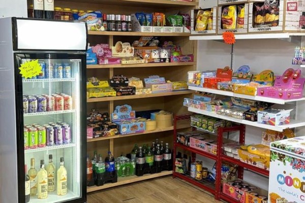 Shelves inside a store filled with beverages, snacks, and candy, next to a refrigerator. - 1 - 1648 Taunton Rd Road E, Clarington