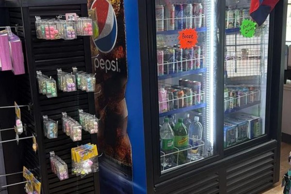 Close-up of store shelving displaying candy, next to a Pepsi branded cooler and a beverage refrigerator. - 1 - 1648 Taunton Rd Road E, Clarington
