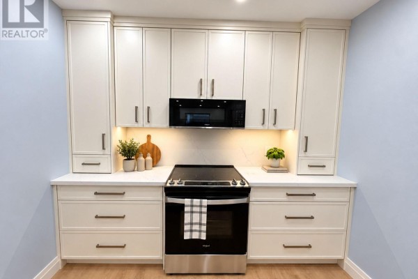 Kitchen with cream cabinetry, stainless steel appliances, and a central stove. - 1 - 1727a Bayview Avenue, Toronto