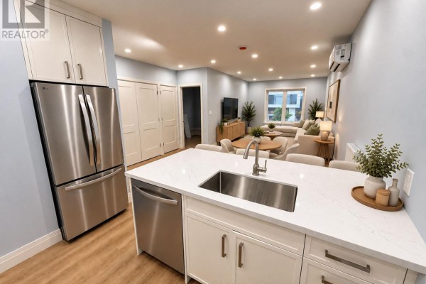 Kitchen island with sink, next to a stainless steel refrigerator and doorways. - 1 - 1727a Bayview Avenue, Toronto