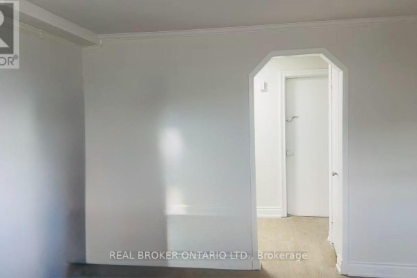 Interior view of a room with white walls and an arched doorway leading to a hallway. - 1 - 202 O'connor Drive, Toronto