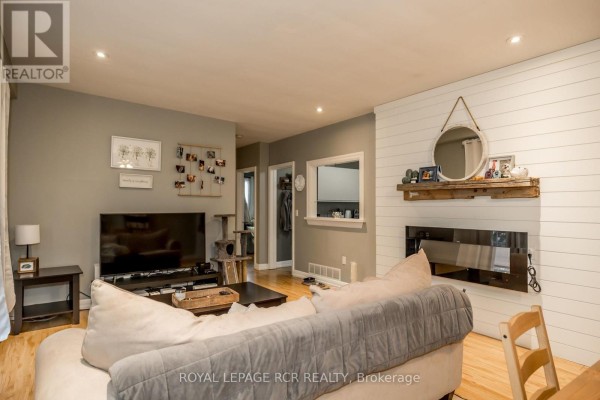 Living room showcasing a sectional sofa, TV, and decorative wall accents - 1 - 22 Centre Street, Bradford West Gwillimbury