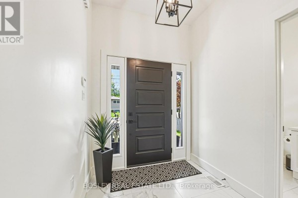 Interior view of a foyer with a staircase, wooden banister, carpeted stairs, and light wood floors. - 1 - 2727 Prince William Street, Lincoln