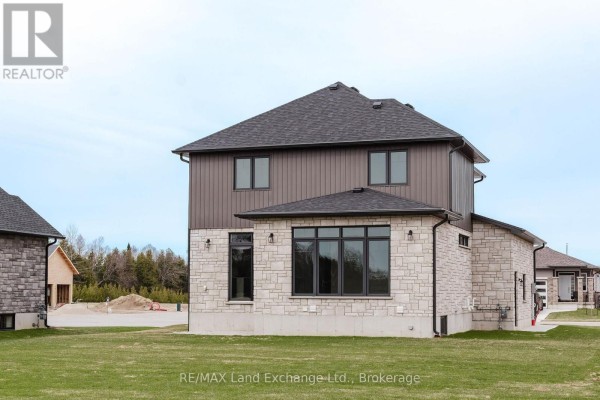 Rear view of a modern two-story house with stone siding and large windows. - 1 - 278 Mary Rose Avenue, Saugeen Shores