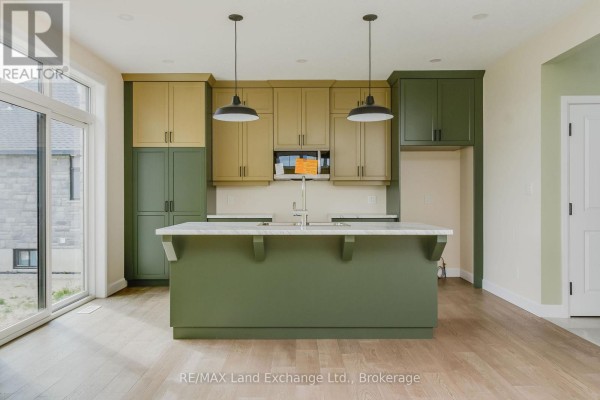 Spacious kitchen with a large island, ample storage, and a sliding glass door to the outside. - 1 - 278 Mary Rose Avenue, Saugeen Shores