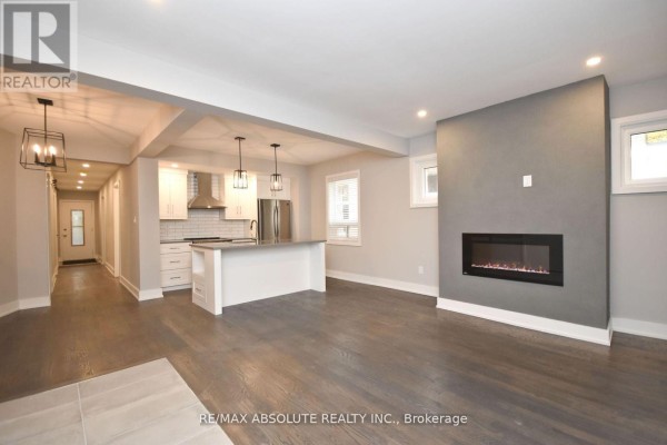 Open concept living area with modern kitchen, island, and electric fireplace. - 1 - 280 Daly Avenue, Ottawa