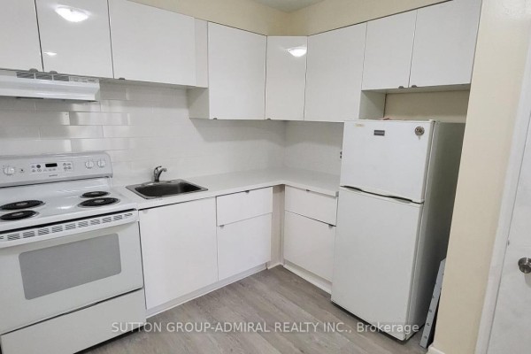 Compact kitchen with white cabinetry, stove, and refrigerator. - 1 - 2839 Bathurst Street, Toronto