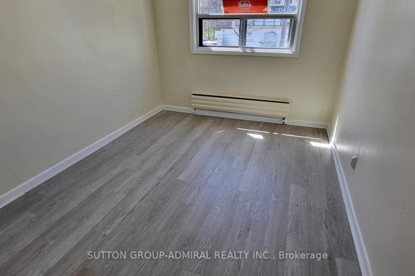 Small bedroom with window, baseboard heating, and laminate flooring. - 1 - 2839 Bathurst Street, Toronto