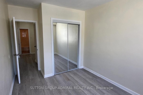 Bedroom featuring mirrored closet doors and access to another room. - 1 - 2839 Bathurst Street, Toronto