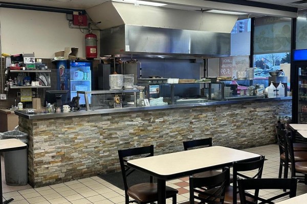 Serving counter with stone facade, stainless steel equipment, and drinks cooler. - 1 - 31 Tapscott Road, Toronto