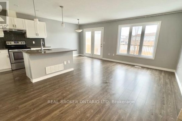 Interior view of a kitchen and living area with dark wood laminate flooring and light grey walls. - 1 - 3400 Castle Rock Place, London South