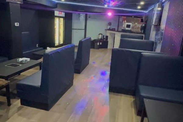 Room with dark blue walls, rows of red chairs with gold frames, and several square tables. - 1 - 3406 Kingston Road, Toronto